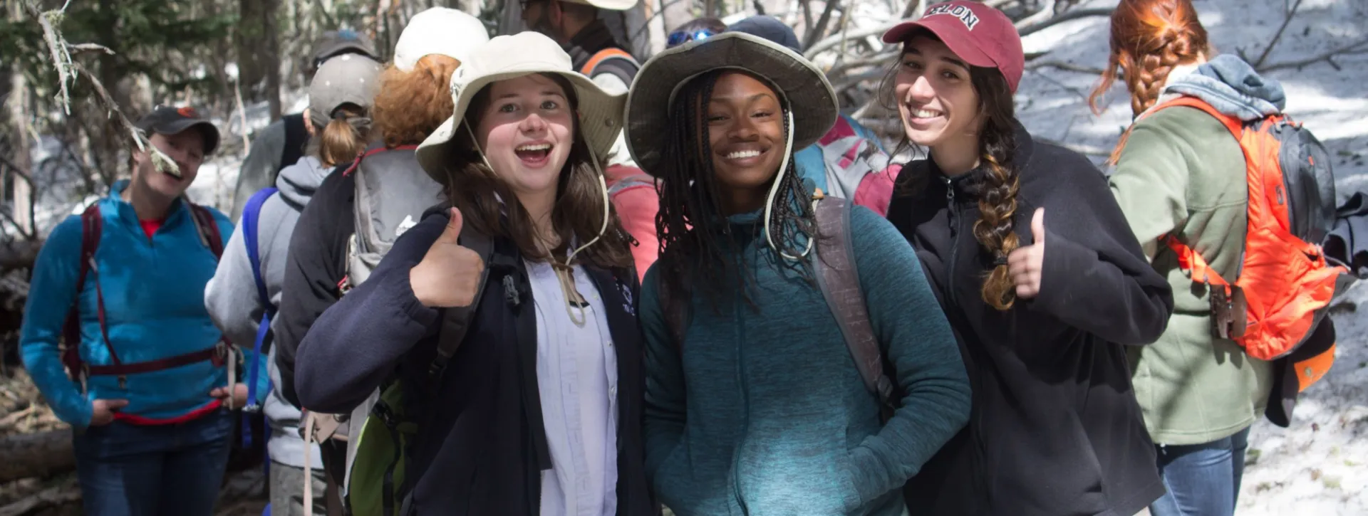Students on field trip, in hats, smiling