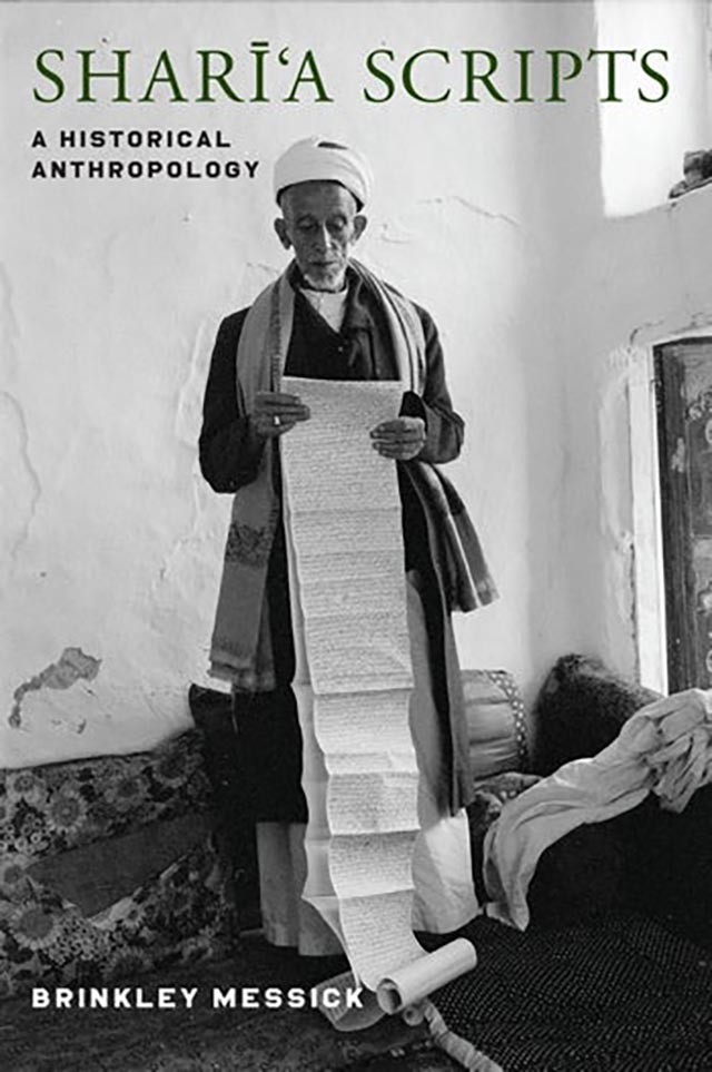 Shari'a Scripts man holding a long piece of paper 
